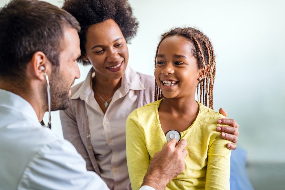Doctor with young patient and mother